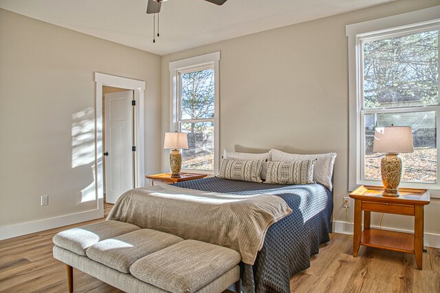 bedroom featuring light wood-type flooring, a ceiling fan, and baseboards