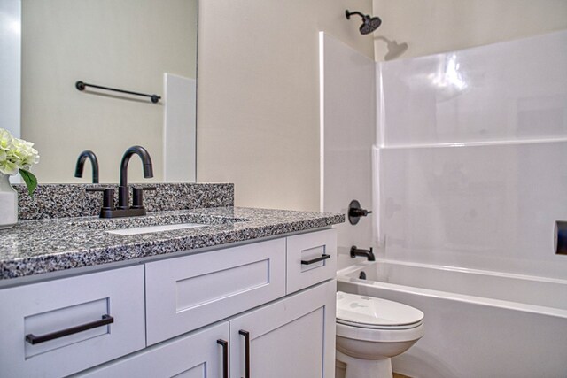 bathroom featuring  shower combination, vanity, and toilet