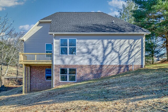 back of house featuring a shingled roof