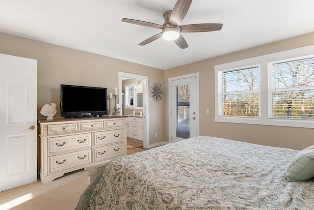 bedroom featuring ensuite bathroom, access to outside, a ceiling fan, and light colored carpet