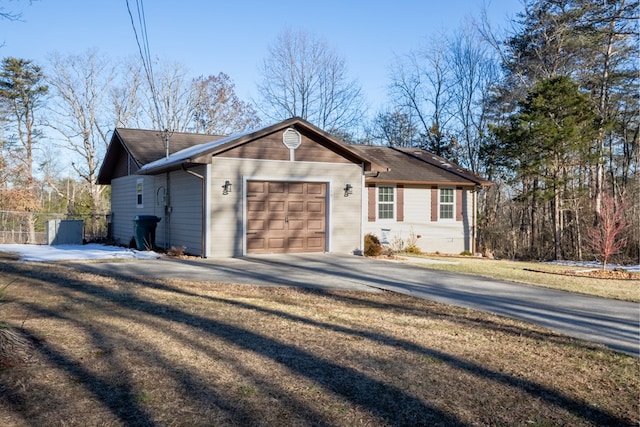 ranch-style home with a garage, driveway, and fence