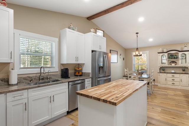 kitchen featuring white cabinets, a kitchen island, stainless steel appliances, and a sink