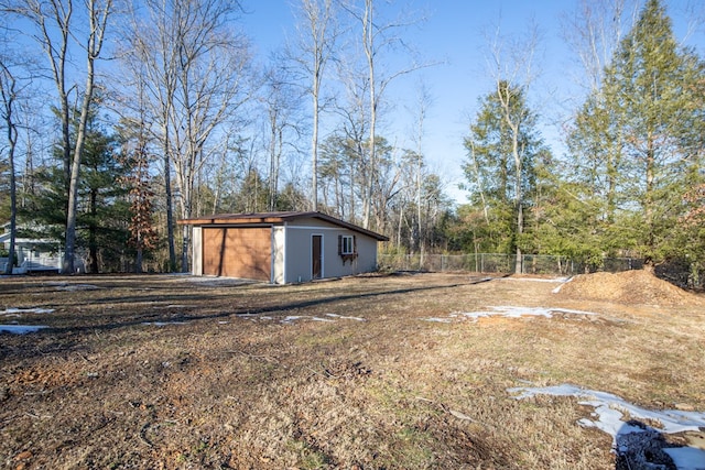 view of yard featuring a garage, fence, and an outdoor structure