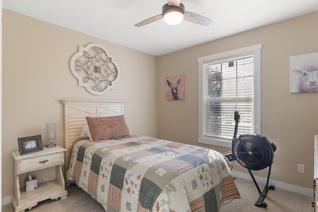 bedroom featuring multiple windows, baseboards, a ceiling fan, and light colored carpet