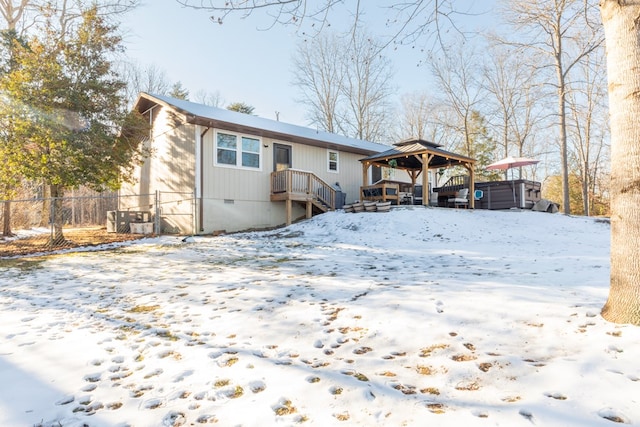 view of front of home featuring a gazebo, crawl space, fence, and a jacuzzi