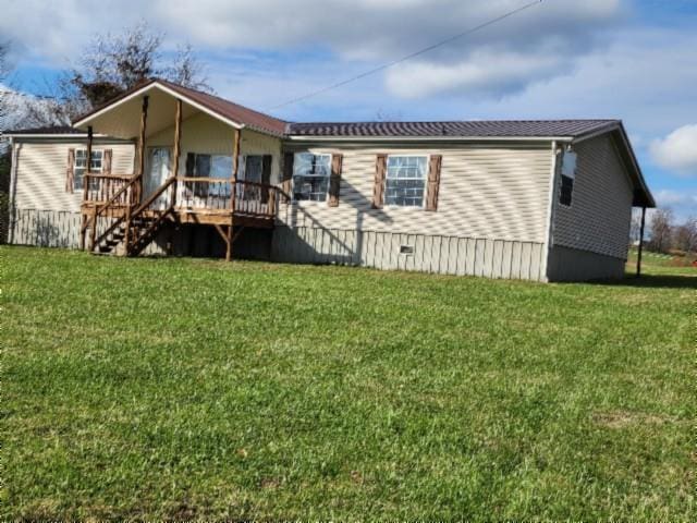 rear view of property with stairs, crawl space, and a lawn