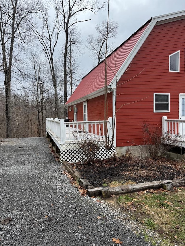 view of side of property featuring metal roof and a wooden deck