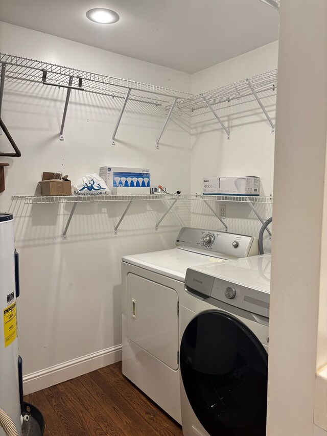 laundry room featuring laundry area, baseboards, dark wood-style floors, washing machine and dryer, and water heater