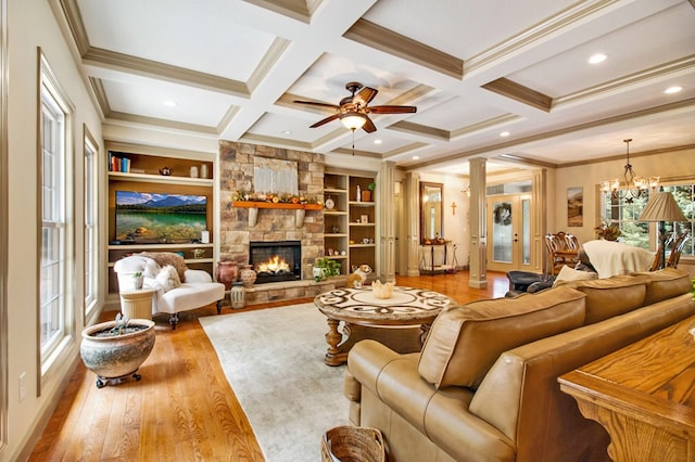 living area featuring a fireplace, light wood-style floors, a healthy amount of sunlight, coffered ceiling, and beamed ceiling