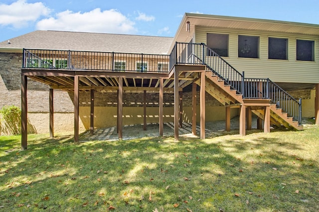 rear view of property featuring stairway, a wooden deck, and a lawn