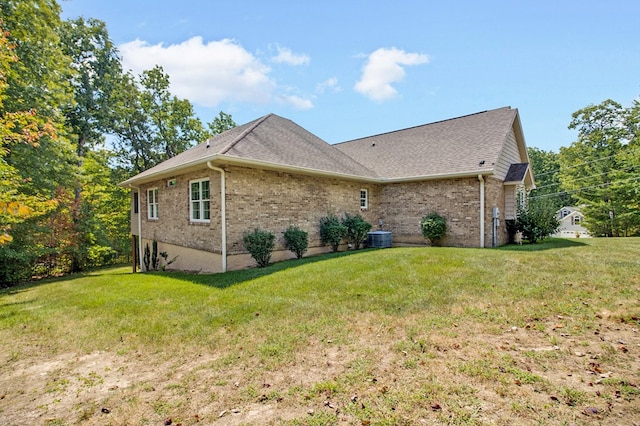 view of side of home featuring central AC, a lawn, and brick siding