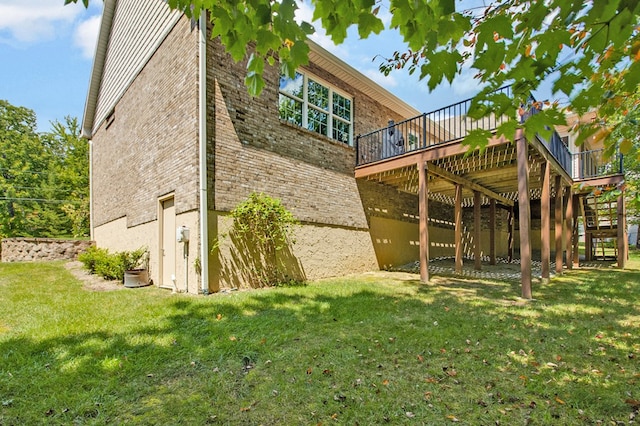 back of house featuring a yard, brick siding, stairway, and a wooden deck