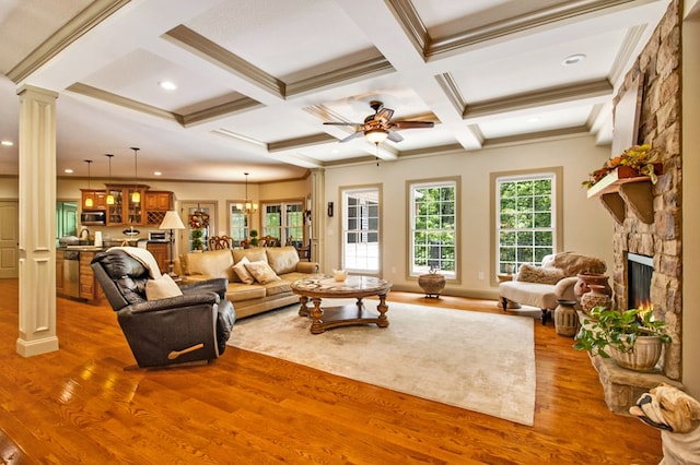 living room with coffered ceiling, wood finished floors, ornate columns, a fireplace, and beam ceiling