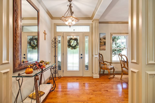 foyer entrance with ornamental molding and light wood-type flooring