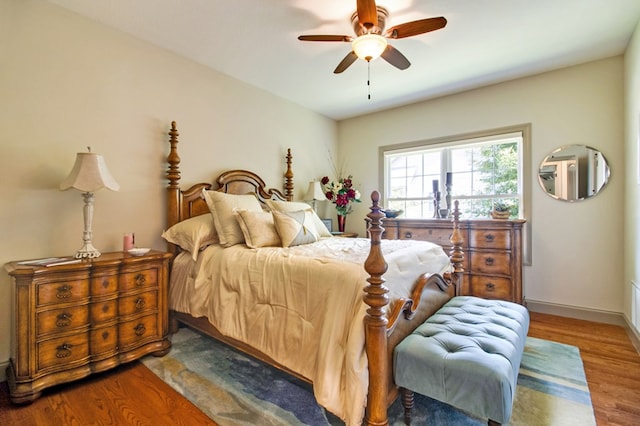 bedroom with ceiling fan, baseboards, and wood finished floors