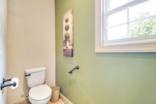 half bath featuring toilet and baseboards