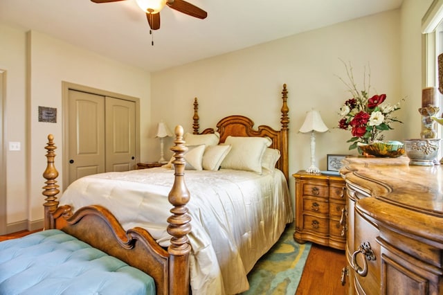 bedroom with ceiling fan, a closet, and dark wood-style flooring