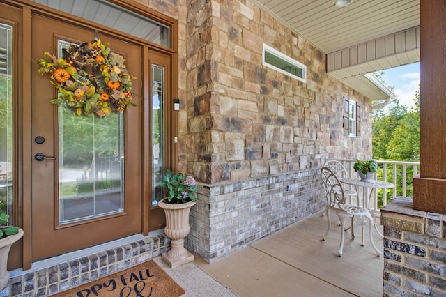 property entrance with a porch and stone siding