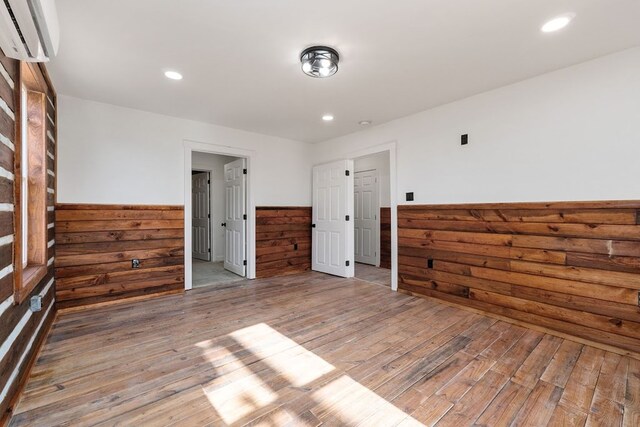 kitchen featuring wainscoting, stone finish flooring, light countertops, water heater, and a sink