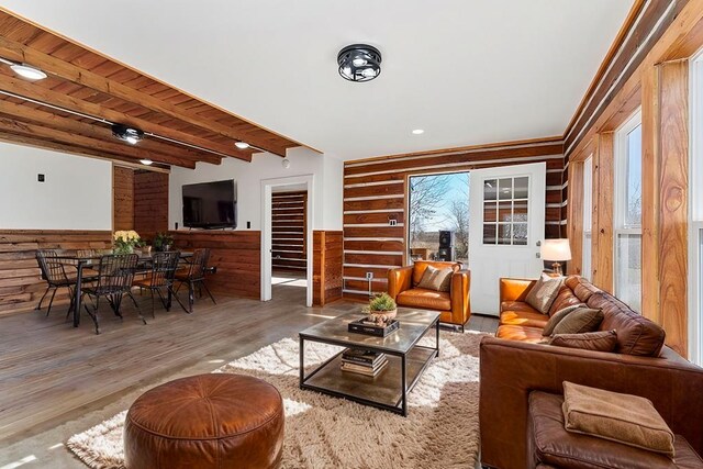 spare room with a wall mounted AC, wainscoting, wood finished floors, and beam ceiling