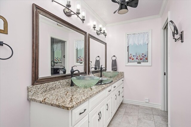 full bath with ornamental molding, a sink, baseboards, and double vanity