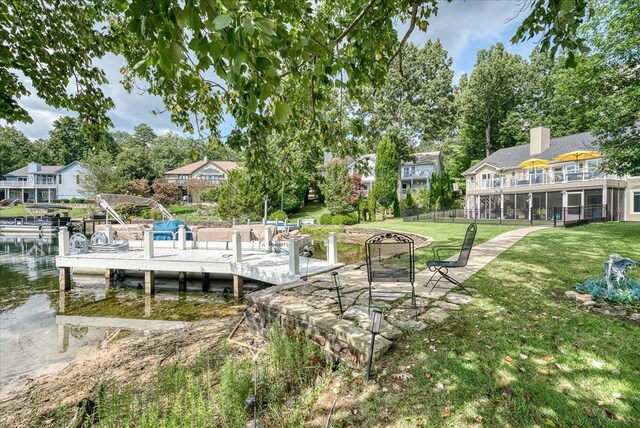 dock area with a water view, a pergola, and a yard