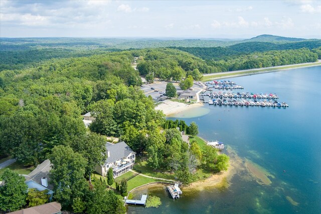 drone / aerial view featuring a water view and a wooded view