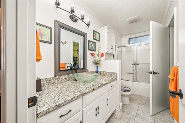 bathroom featuring toilet, shower / bath combination with glass door, a textured ceiling, and vanity