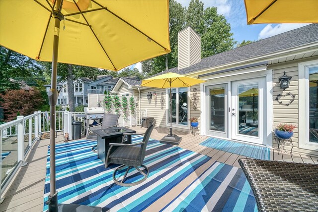 wooden deck featuring an outdoor fire pit and a grill