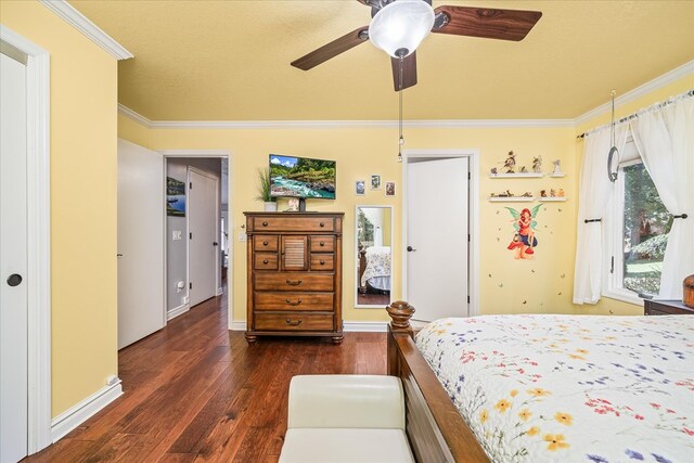 bedroom with ornamental molding, a ceiling fan, baseboards, and dark wood-style floors