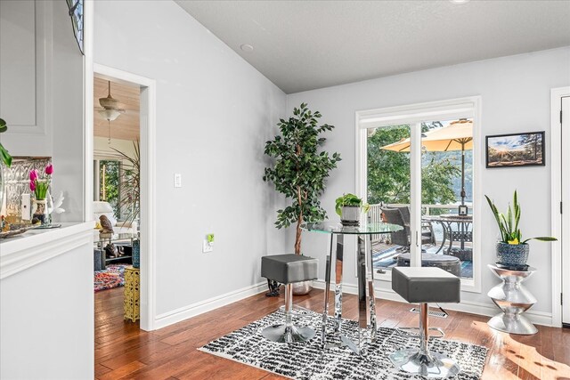 office area with baseboards, vaulted ceiling, and wood finished floors