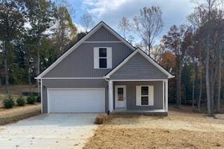 view of front of property featuring covered porch, concrete driveway, and a garage