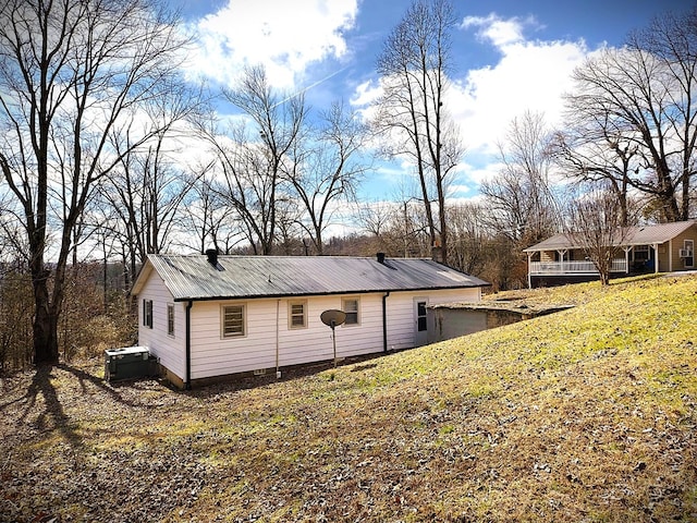 exterior space with metal roof and a lawn