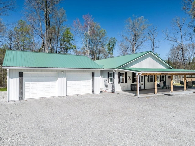 view of front of house featuring a carport, metal roof, driveway, and a porch