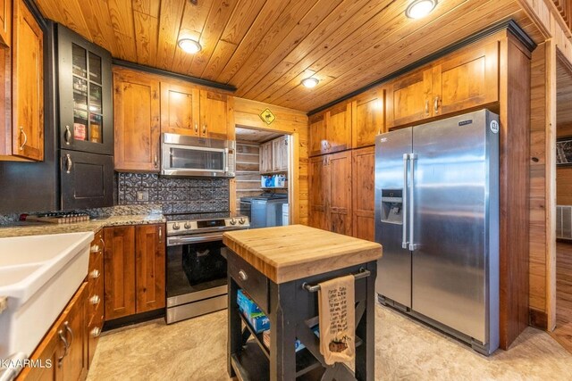 kitchen with brown cabinets, stainless steel appliances, and decorative backsplash