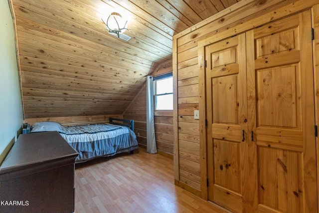 bedroom featuring wooden walls, lofted ceiling, wooden ceiling, and light wood-style flooring