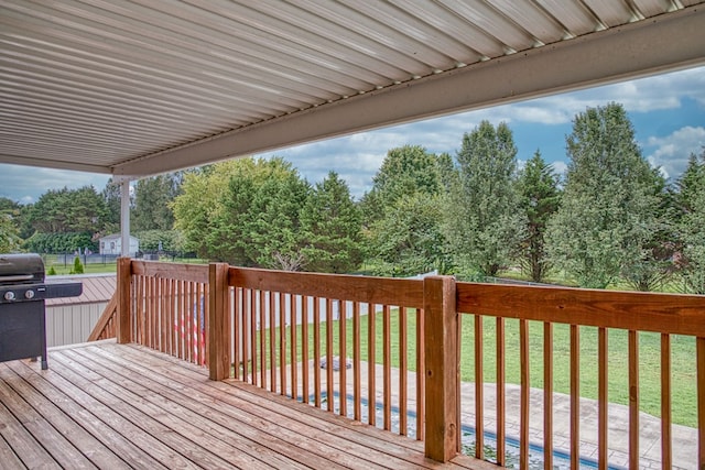 wooden terrace featuring a grill and a lawn