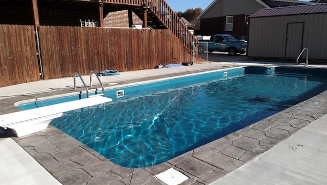 view of swimming pool featuring fence and an outbuilding