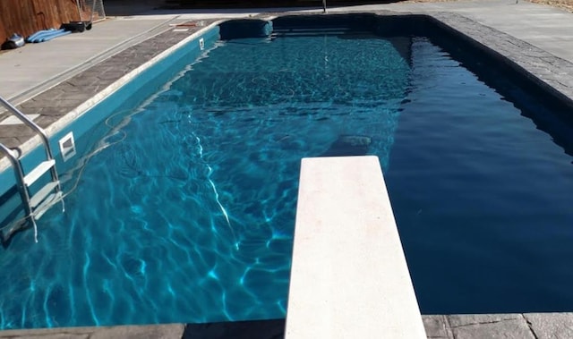 outdoor pool featuring a diving board