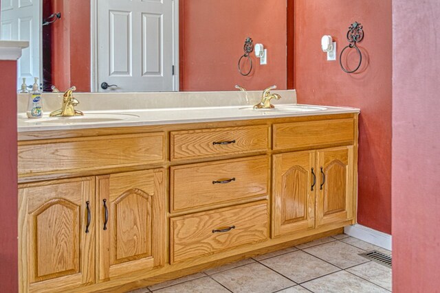 bathroom featuring double vanity, tile patterned flooring, visible vents, and a sink