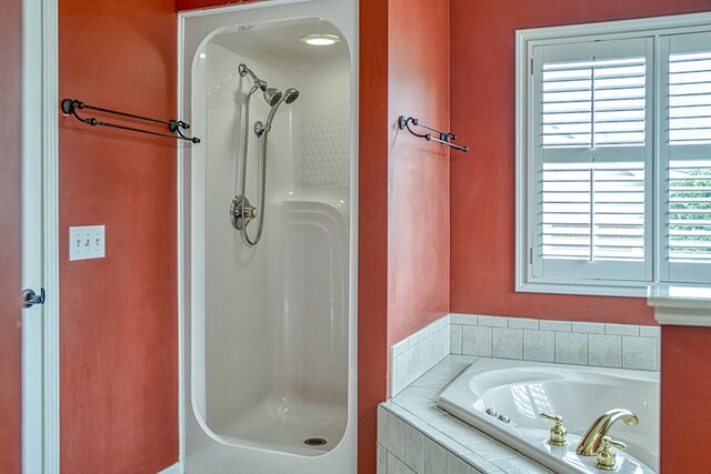 bathroom featuring a garden tub and a walk in shower