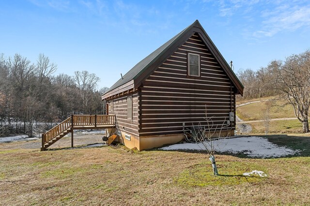 view of side of home with stairway, log siding, a lawn, and a wooden deck