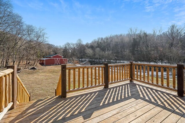 wooden deck featuring a storage shed and an outdoor structure