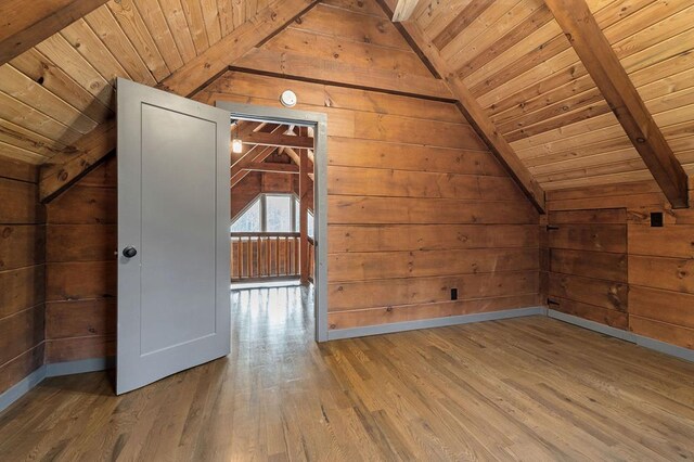 additional living space featuring vaulted ceiling with beams, wooden ceiling, wooden walls, and wood finished floors