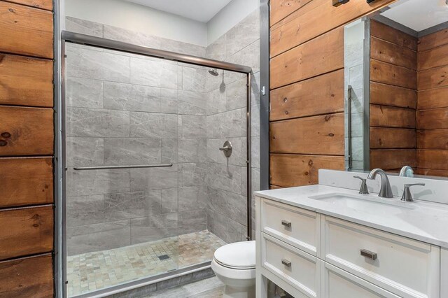 bathroom with toilet, a stall shower, and vanity