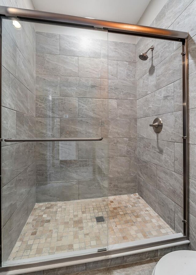 bathroom with a stall shower and toilet