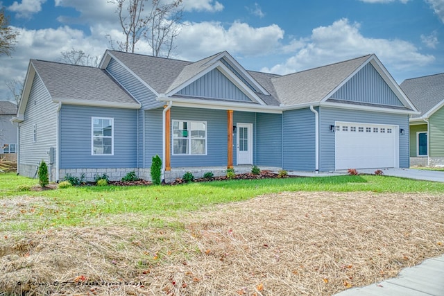 view of front of home featuring a garage, a shingled roof, aphalt driveway, covered porch, and a front lawn