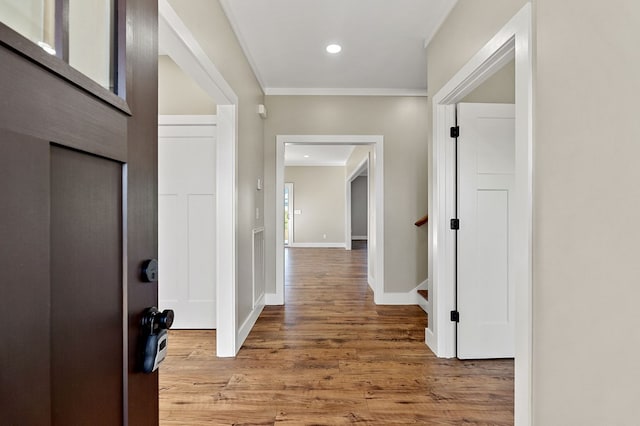 hallway featuring stairs, baseboards, wood finished floors, and recessed lighting