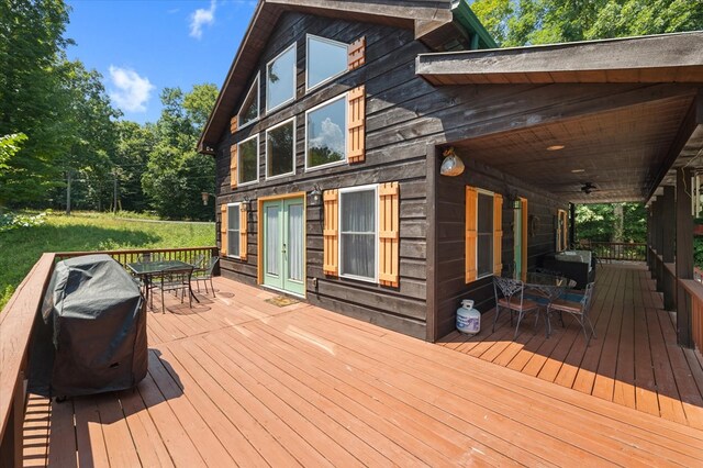 deck featuring outdoor dining area and a grill