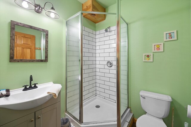 bathroom with a stall shower, vanity, and toilet